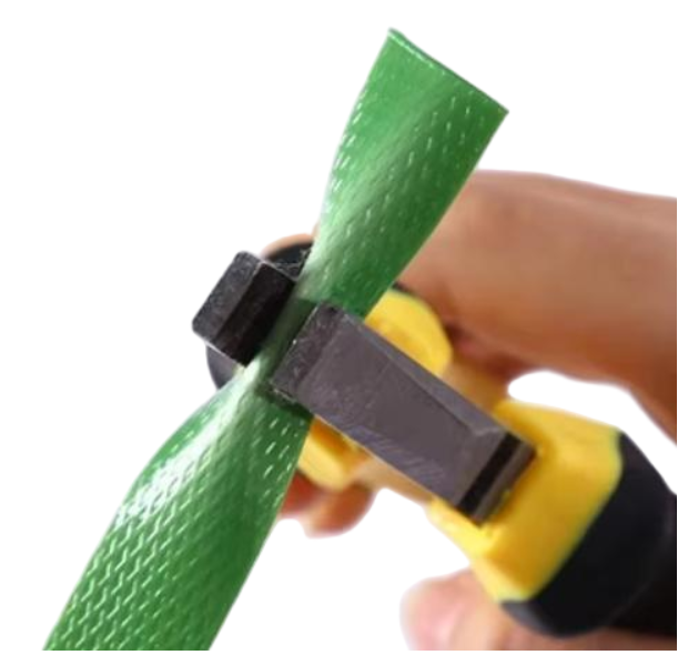Hand tool demonstration cutting PET strapping during packaging use.